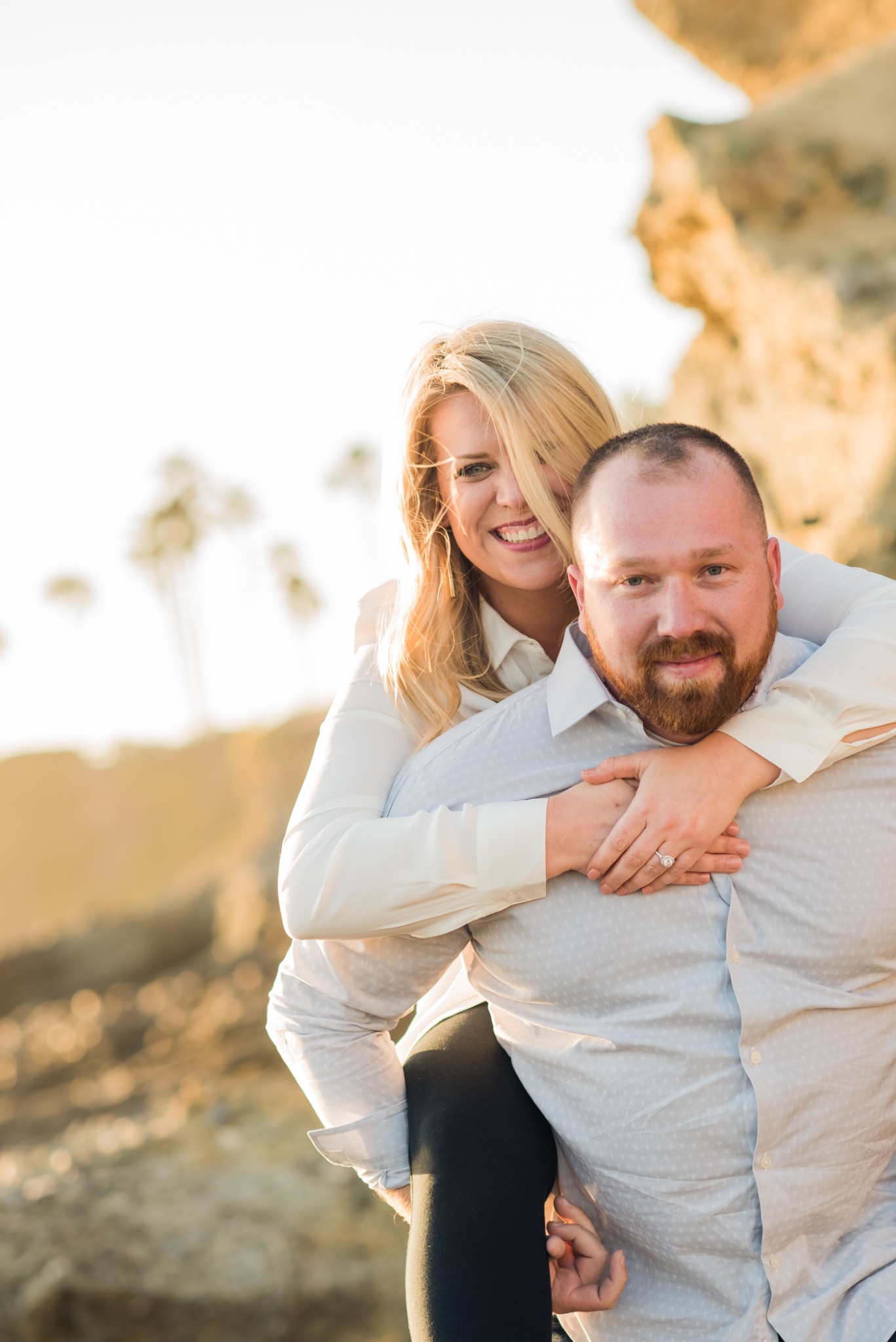 Couple sharing a playful embrace in warm coastal light