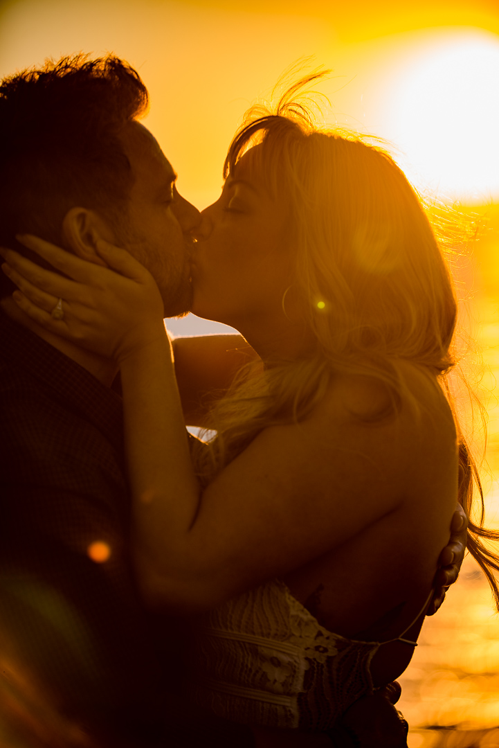 Couple kissing in a dramatic golden sunset