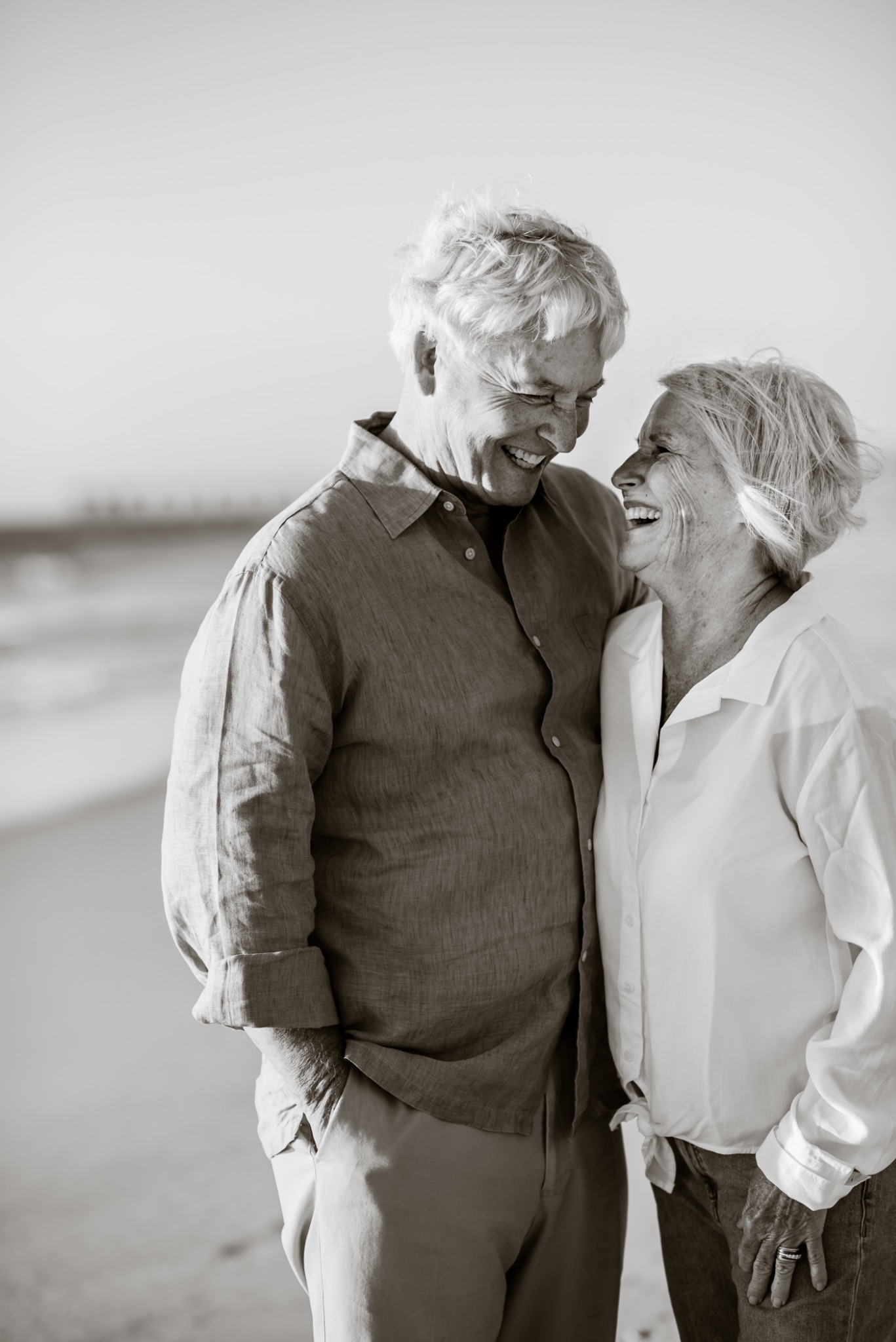 Older couple laughing together at the beach