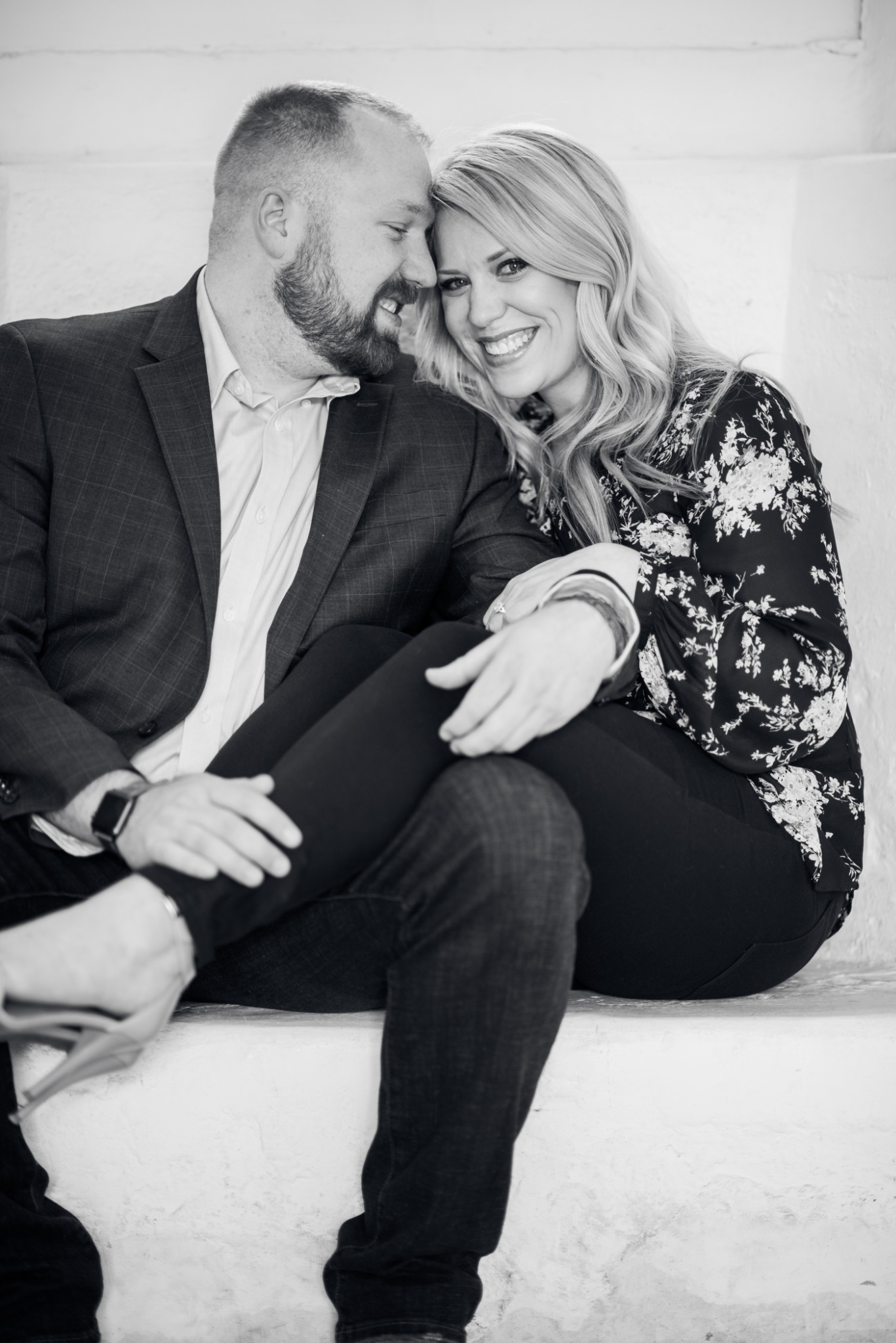 Couple seated closely together in a refined black-and-white portrait