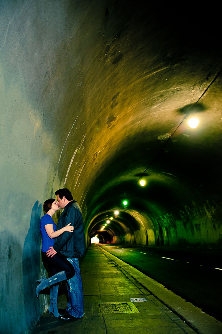 Couple embracing beneath a dramatic tunnel