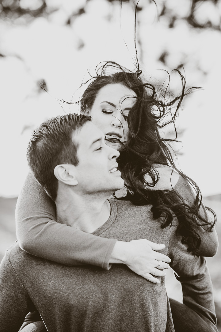 Couple sharing a windswept embrace in black and white