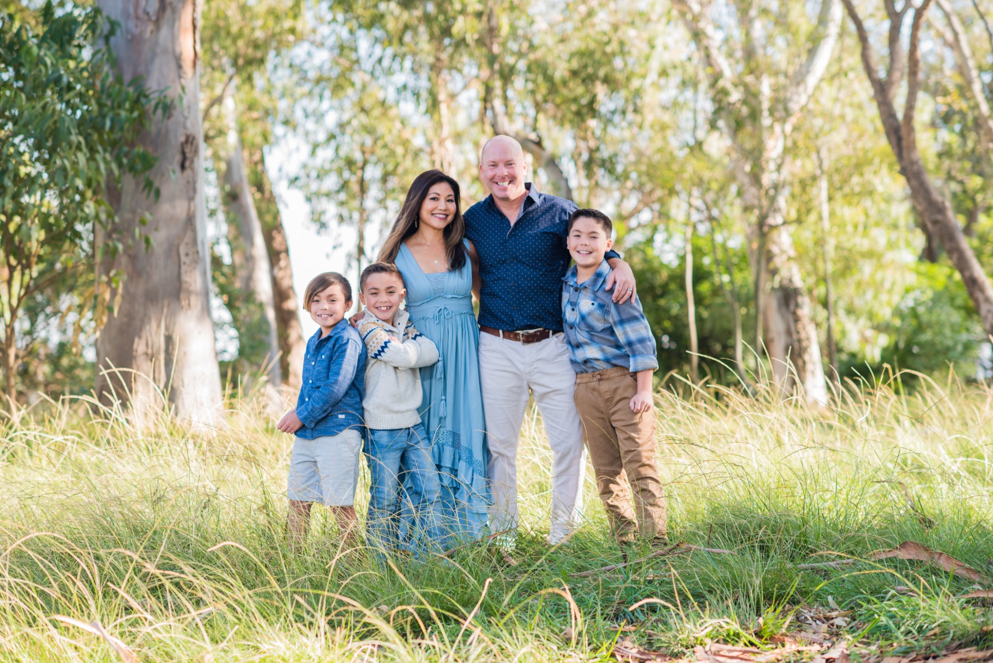 Family portrait among sunlit trees